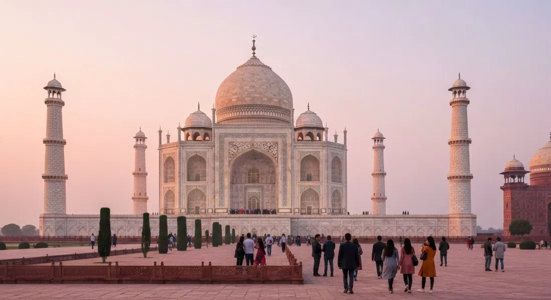 the Taj Mahal seen from the East Gate side at sunrise, soft pink light on the marble and a sparse line of early visitors in the foreground