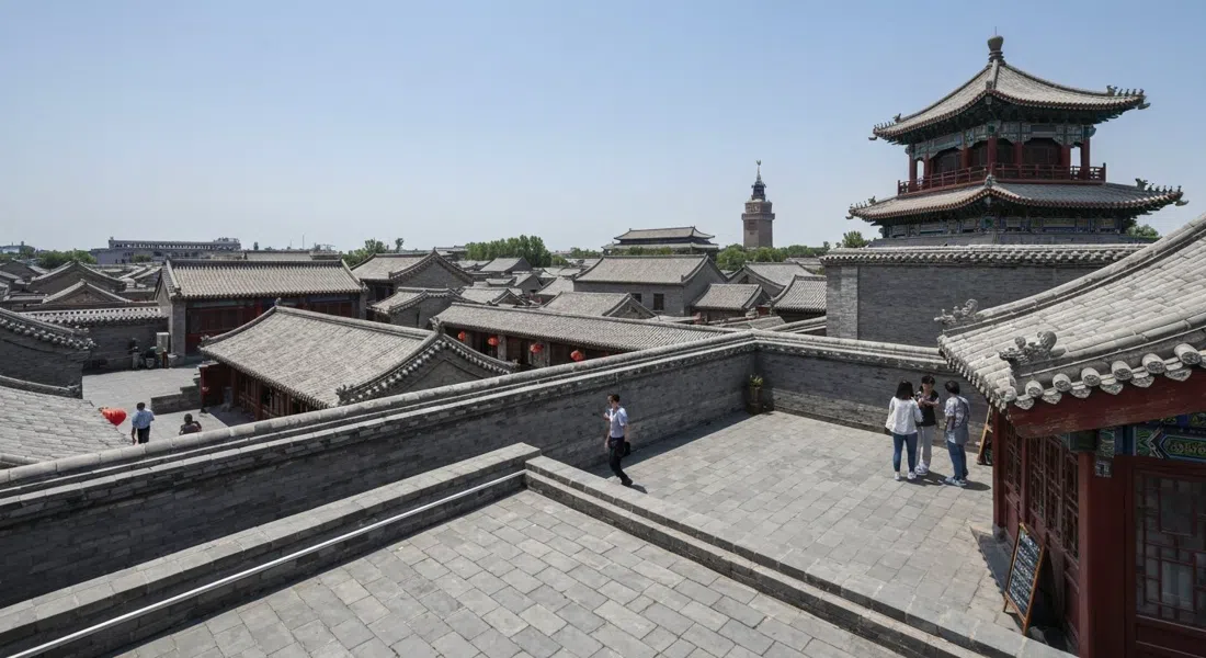 the rooftop view from the Drum Tower over grey-tiled hutong courtyards toward the Bell Tower, seen in clear daylight