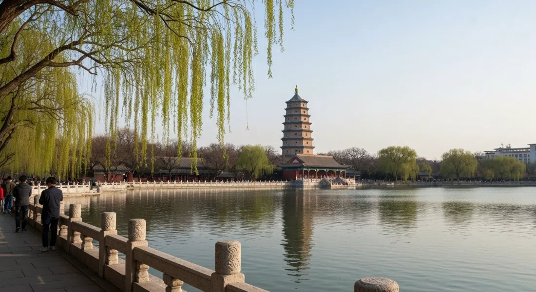 Weiming Lake at Peking University on a calm afternoon, willow branches over the water and the Boya Pagoda rising beyond the lake