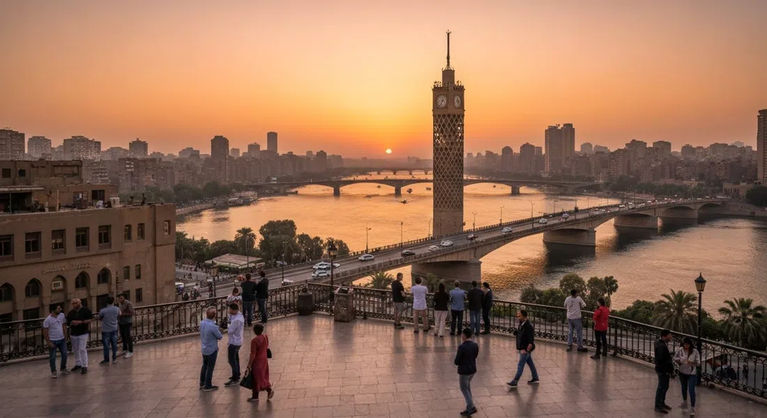 the Cairo Tower observation deck view over the Nile and Cairo skyline at sunset, with the river turning copper and bridges stretching across frame