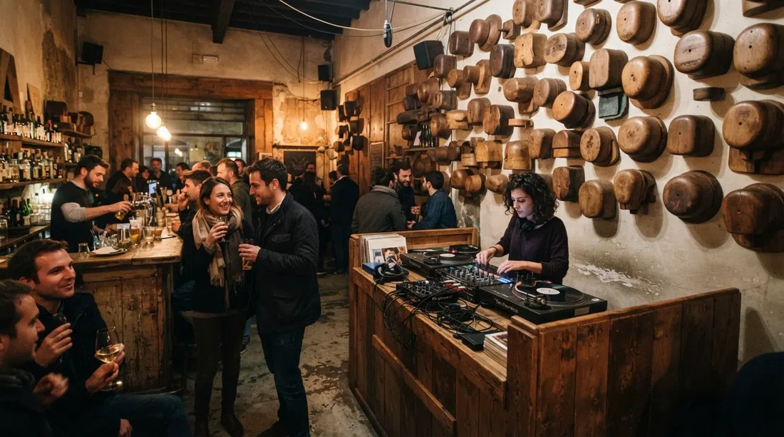 The front room at Volume on Piazza Santo Spirito, old wooden hat-block forms on the walls, a DJ setup and evening bar light