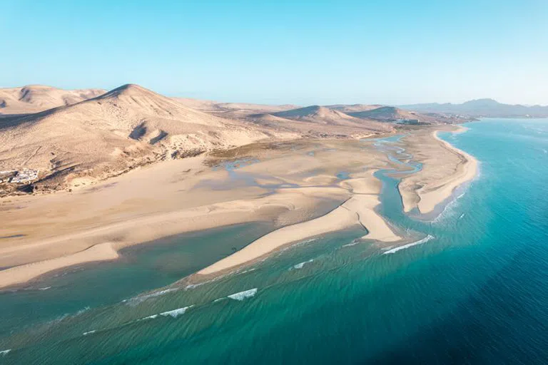 the shallow, reef-sheltered lagoon and pale sand at Playa del Castillo