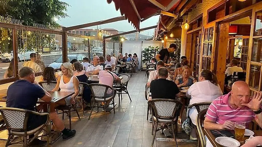 the vine-covered terrace at El Patio, with grilled fish and paella on the tables