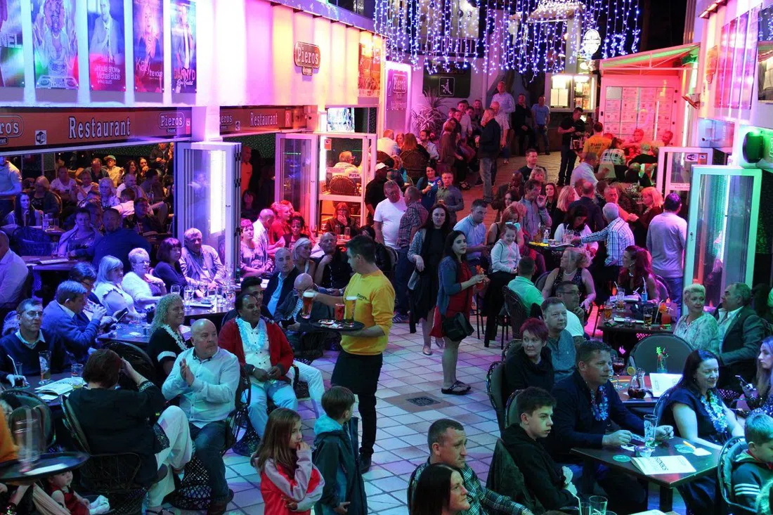 a singer performing to a full room at Piero's Music Cafe