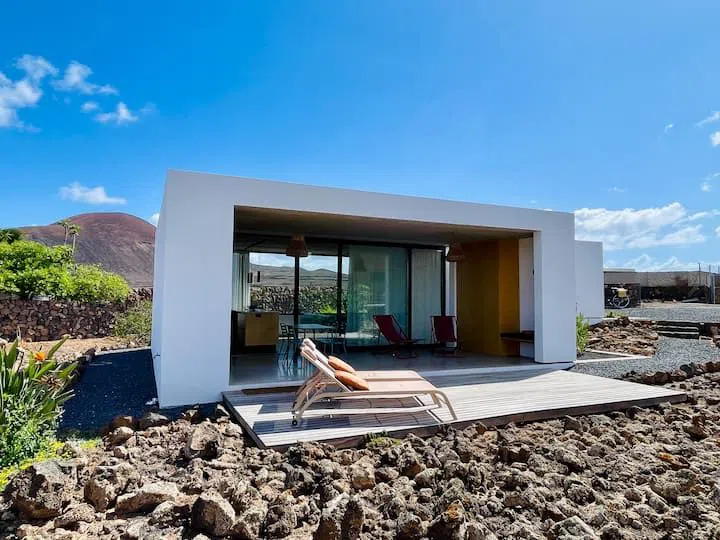 whitewashed houses and dry volcanic-stone walls lining a narrow street in Lajares