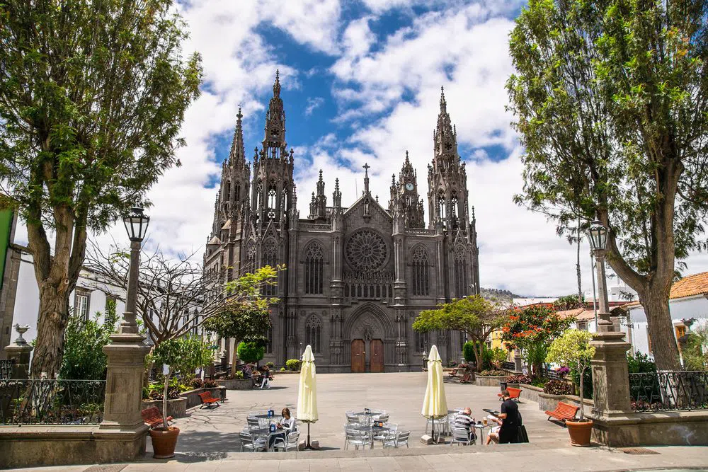 the black volcanic stone facade and spires of the Church of San Juan Bautista in Arucas