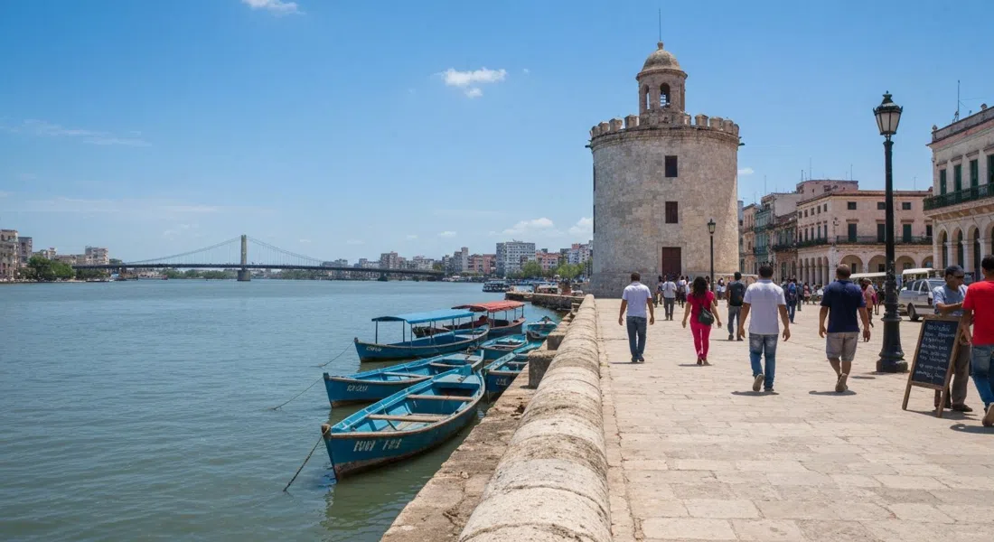 the esplanade beside Torreón de Cojímar, a weather-beaten waterfront edge with skiffs below and the river bridge in view