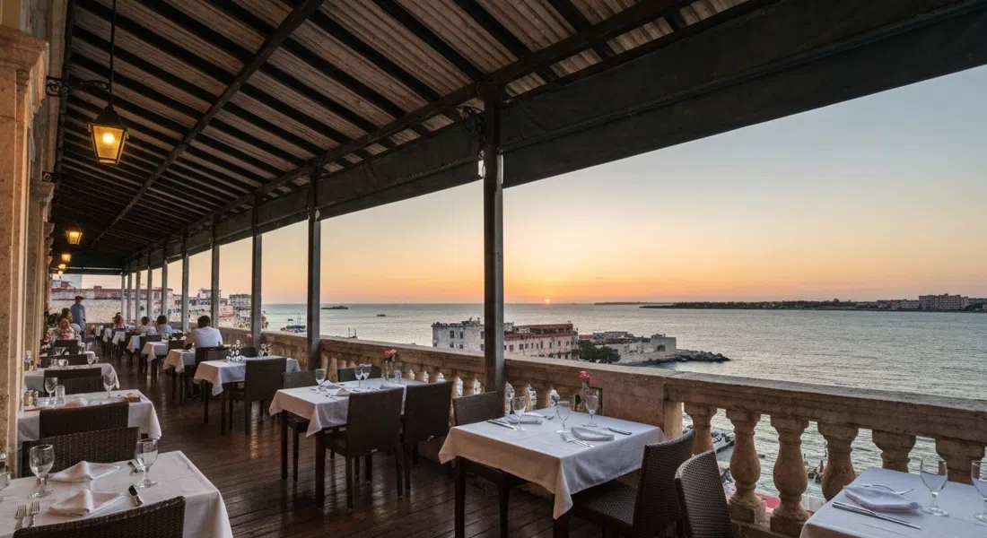 Vistamar’s open terrace at sunset, tables set above the Straits of Florida with warm orange light on the sea beyond