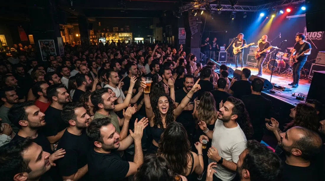 a crowded night at Bios on Kıbrıs Şehitleri Caddesi, big live stage lit up, packed audience, concert energy and raised glasses in a dark room