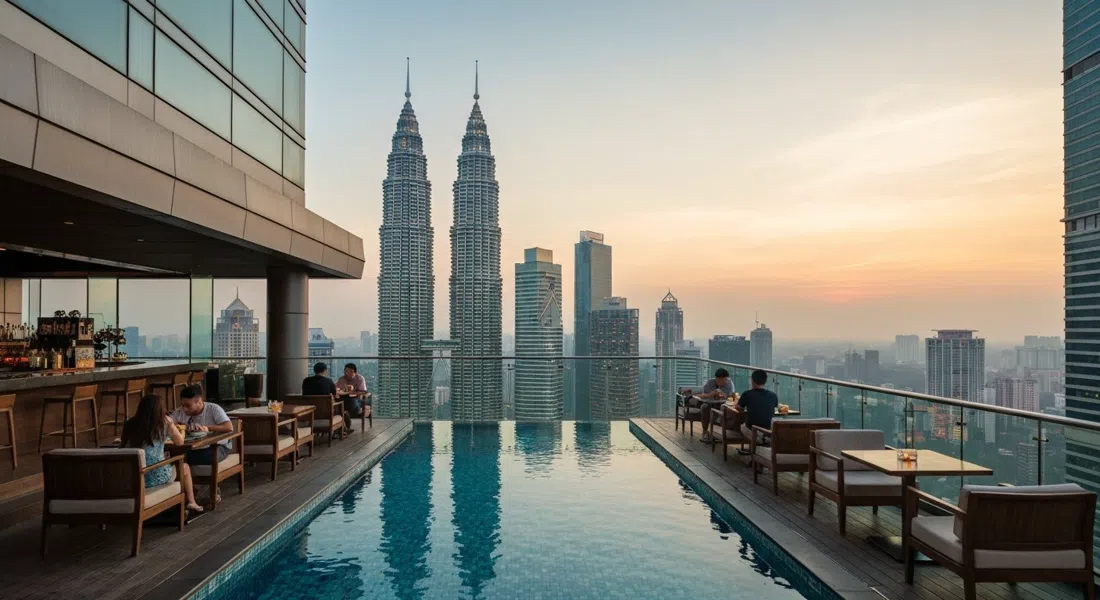 SkyBar at Traders Hotel on the 33rd floor, poolside booths facing the Petronas Twin Towers through the glass at sunset