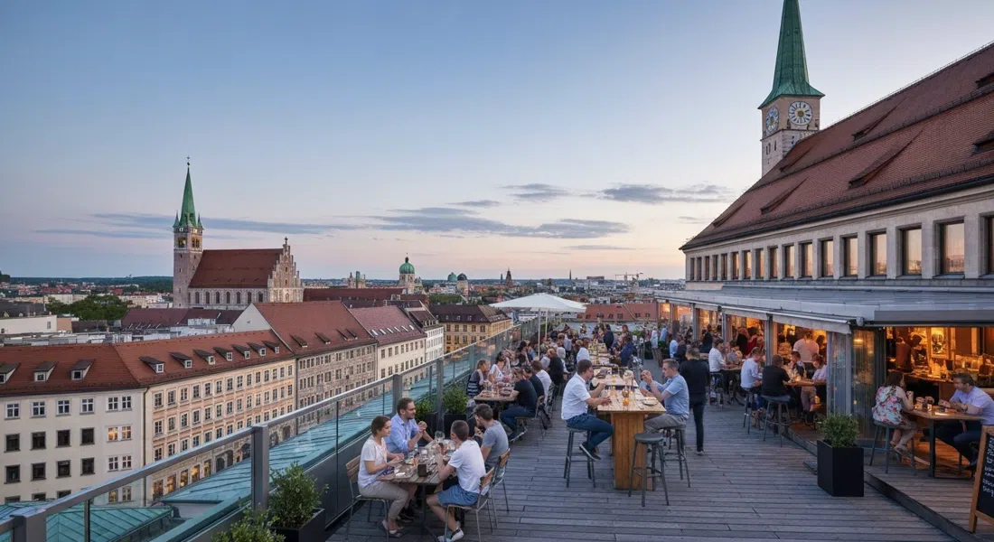 The rooftop terrace at the Deutsche Eiche on Reichenbachstraße in Munich, pre-party crowd with rooftop tables and views over the old city at dusk