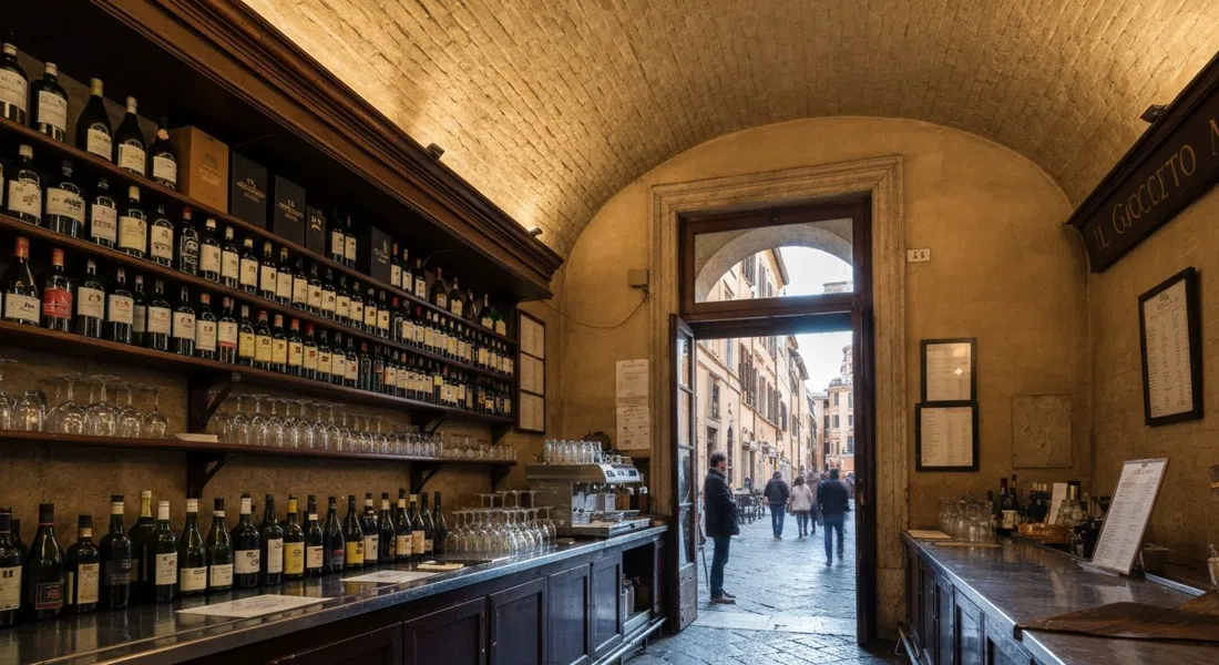 the vaulted interior of Il Goccetto on Via dei Banchi Vecchi, rows of bottles and a few glasses on the bar with evening light at the doorway