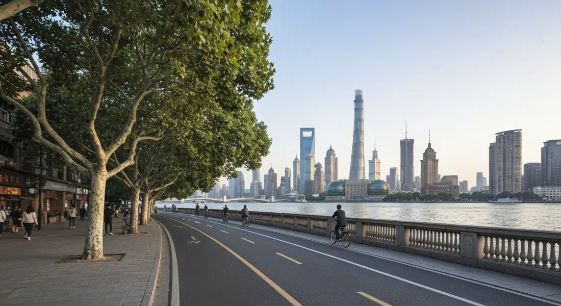 the Xuhui riverfront promenade at West Bund with plane trees, cycle lanes, wide balustrades and Pudong’s towers faint across the Huangpu in late afternoon light