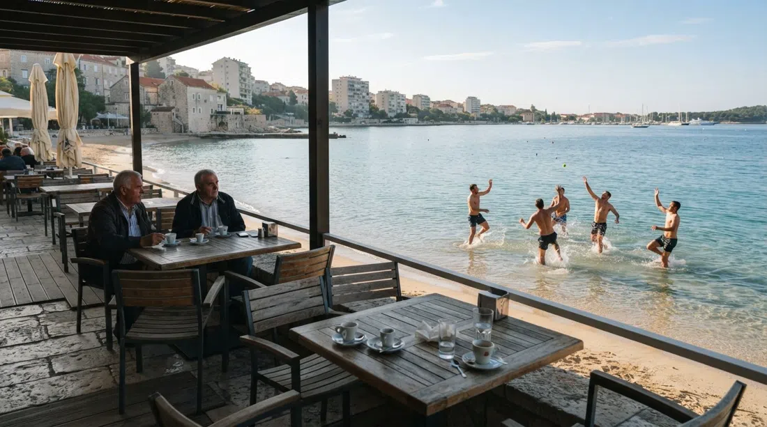 Zbirac terrace bar on Bacvice sand at early morning, coffee cups on tables and picigin players in the shallows just beyond