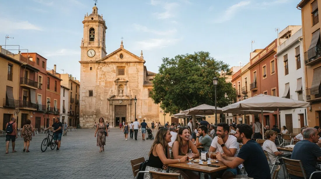 Plaça de Benimaclet with the parish church of the Asunción de Nuestra Señora at the historic core, late-afternoon light on the square and low village houses around it