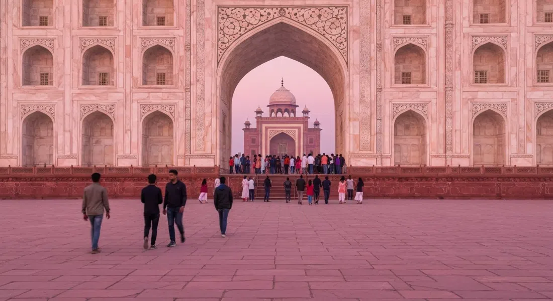 the Taj Mahal at sunrise from the approach side, soft pink light on the marble with early visitors entering through the West Gate