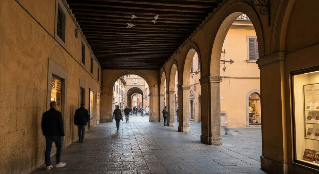 the interior passage of Corte Isolani looking toward Strada Maggiore, with the 13th-century oak portico beams and the three arrows visible overhead