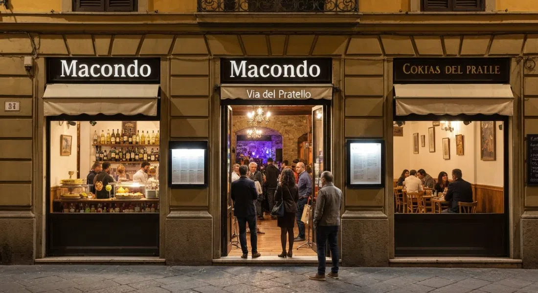 the front of Macondo on Via del Pratello at night, aperitivo buffet glowing inside while a small crowd leans in the doorway with live music spilling from the back room