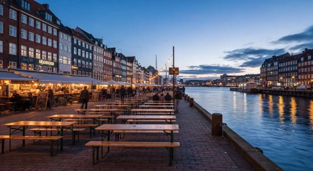 Broens Gadekøkken at dusk by the Inner Harbour Bridge, communal tables, lit stalls and harbour water reflecting the evening sky