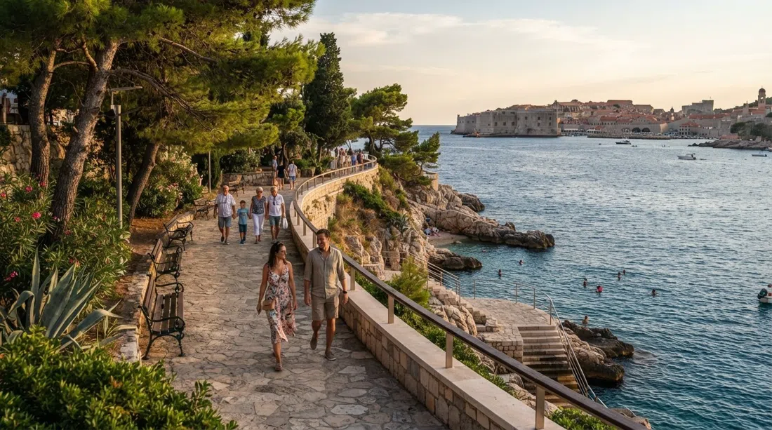 the renovated Šetalište Nika i Meda Pucića coastal promenade on Babin Kuk at late-afternoon light, with pine trees, benches and the Adriatic below