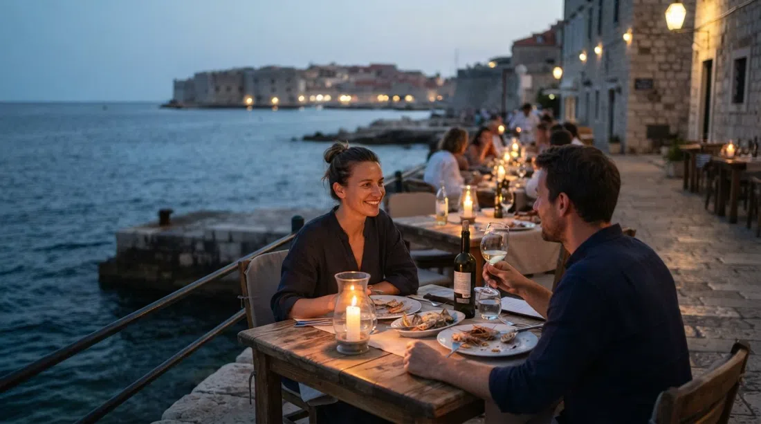 Restaurant Levanat’s stone terrace at dusk above the water on Šetalište Nika i Meda Pucića 15, candlelight on tables and the sea just beyond
