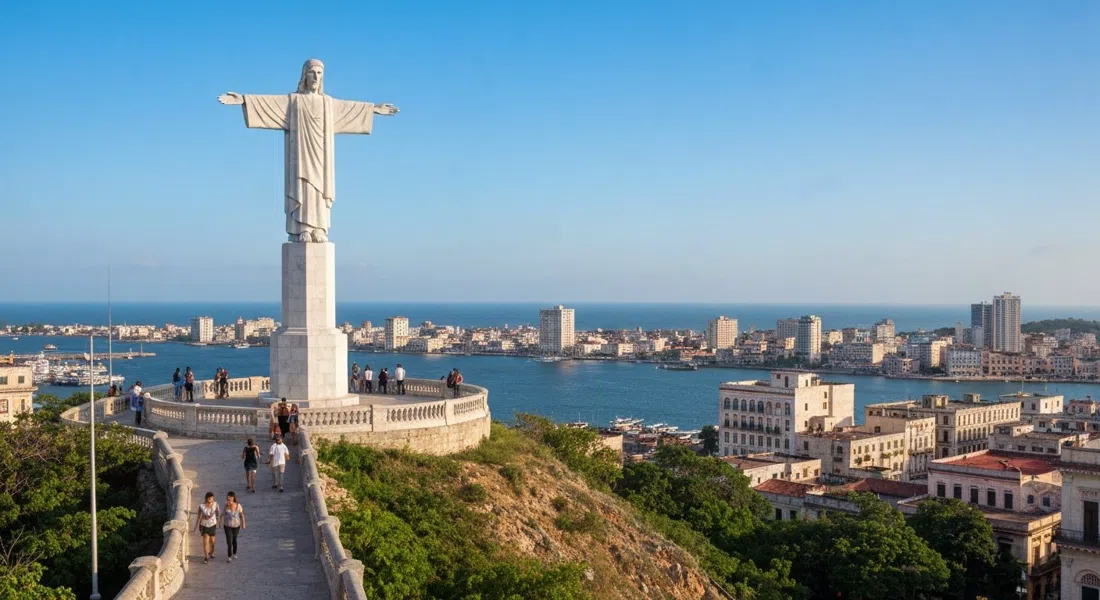 the Cristo de La Habana on its hilltop terrace, white marble figure against a blue harbour and city skyline in late-afternoon light
