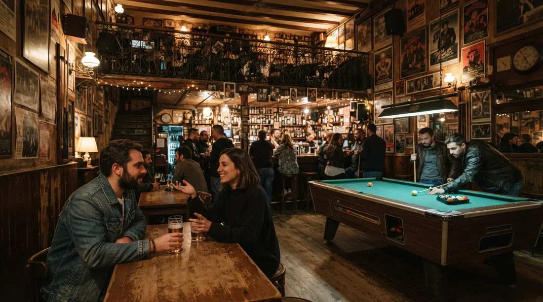 the interior of La Vía Láctea on Calle Velarde, with vintage posters, a pool table and warm low light filling the two-floor bar