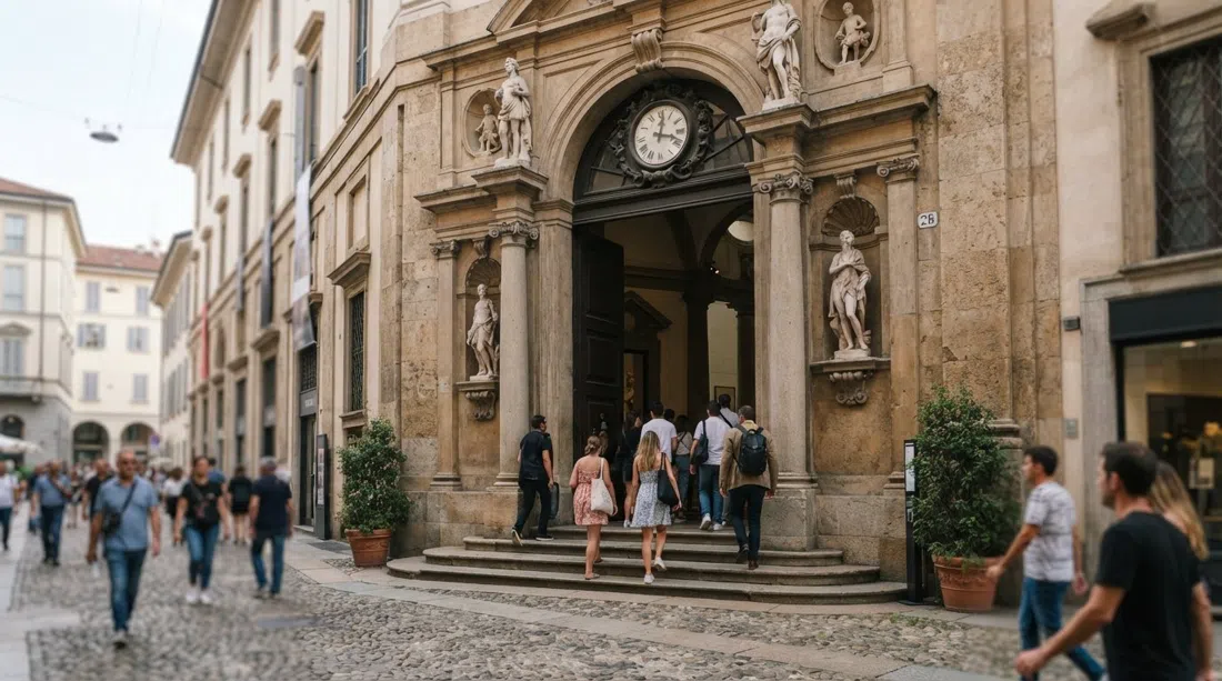 the facade and entrance of the Pinacoteca di Brera on Via Brera 28, with visitors entering under soft daytime light