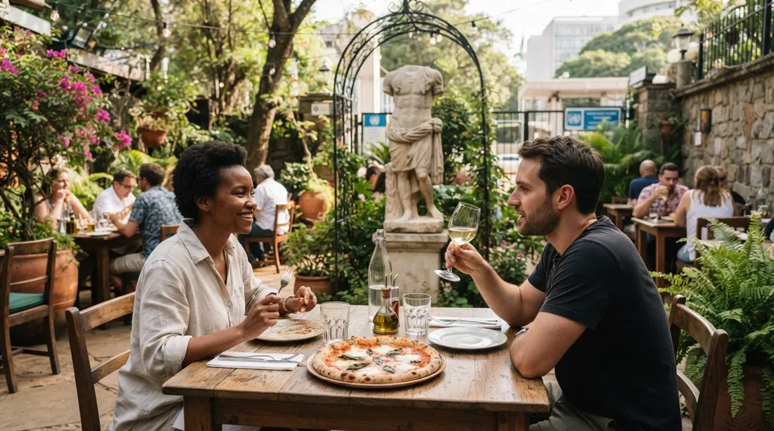 Mediterraneo Ristorante’s garden tables near the UN entrance, with Roman-style sculpture and a wood-fired pizza on a casual lunch table