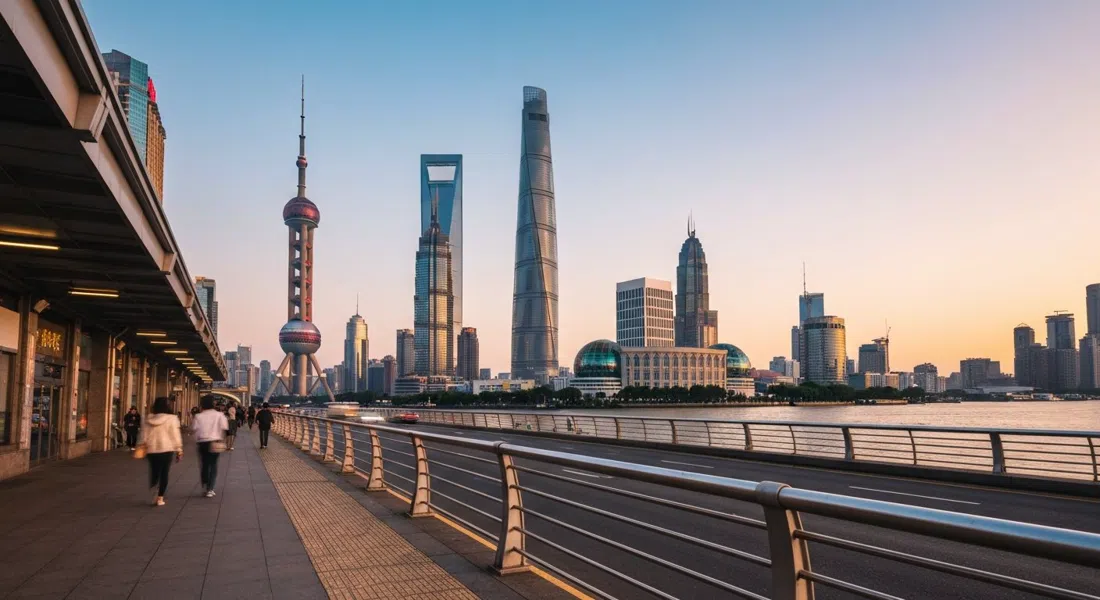 the Oriental Pearl Tower, Jin Mao Tower, Shanghai World Financial Center and Shanghai Tower clustered above the Huangpu River at late afternoon, seen from a low angle with traffic and footbridge lines in the foreground