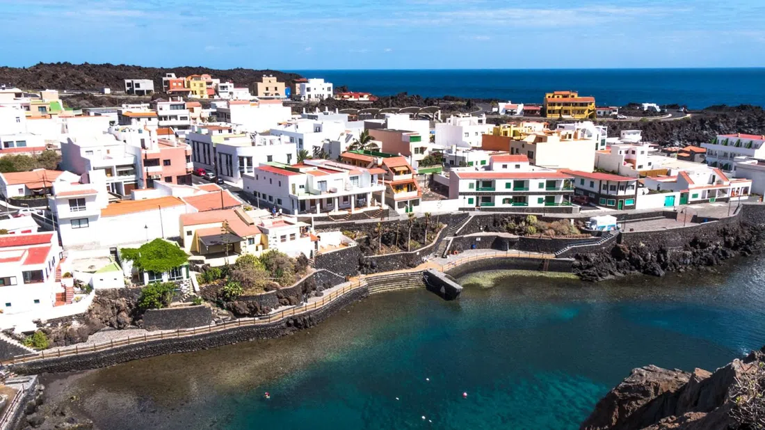Black volcanic sand and whitewashed houses ringing the lagoon at Tamaduste, El Hierro