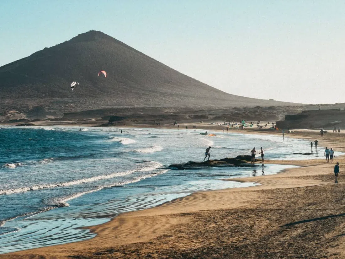 El Médano beach, 750 metres of grey volcanic sand with kite and windsurf sails on the water